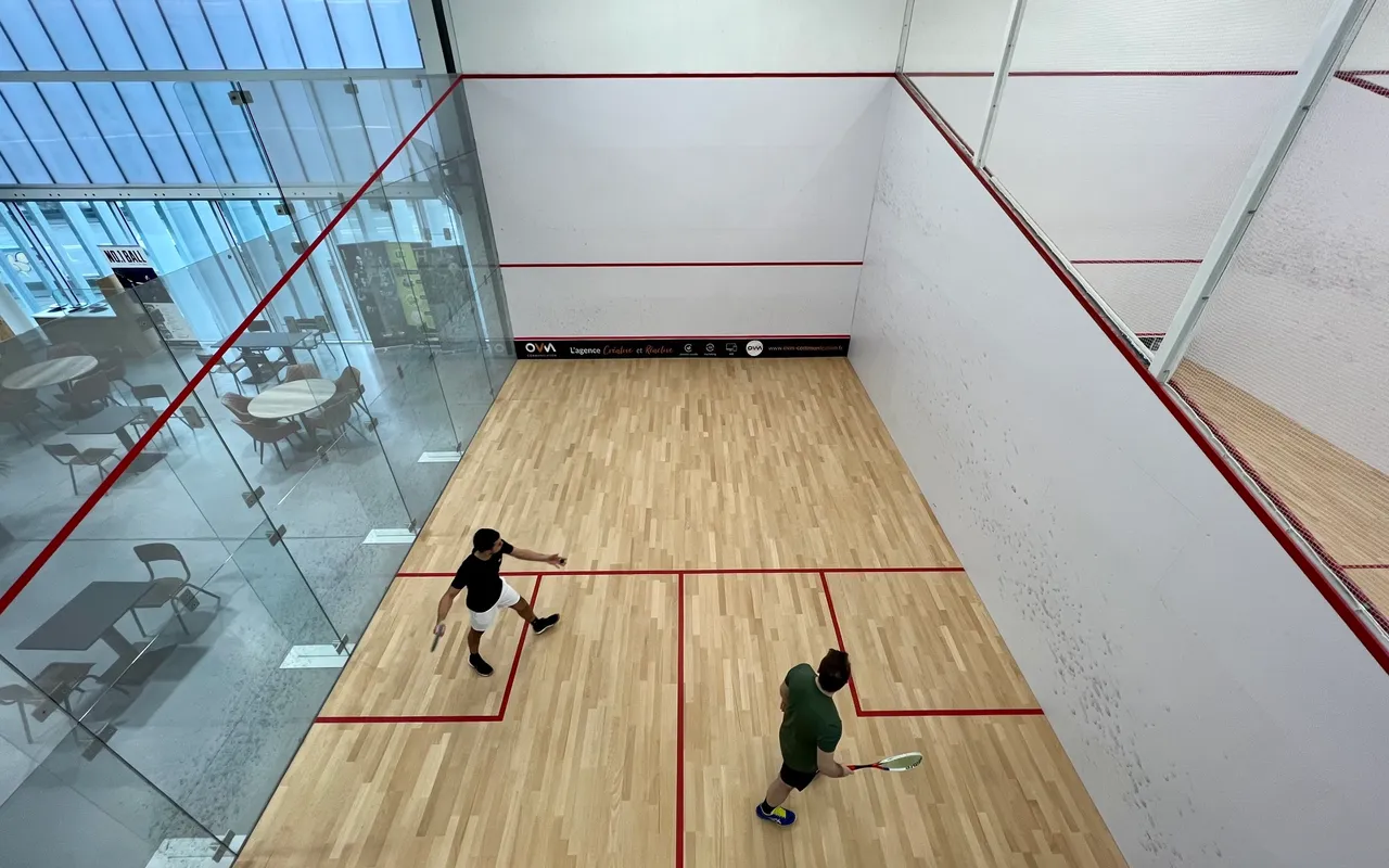 Partie de squash au LIL à Lille, bâche OVM Communication en fond de court